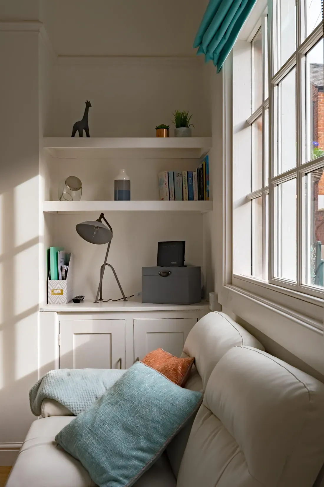 Cozy residential living room corner with built-in shelving and natural light